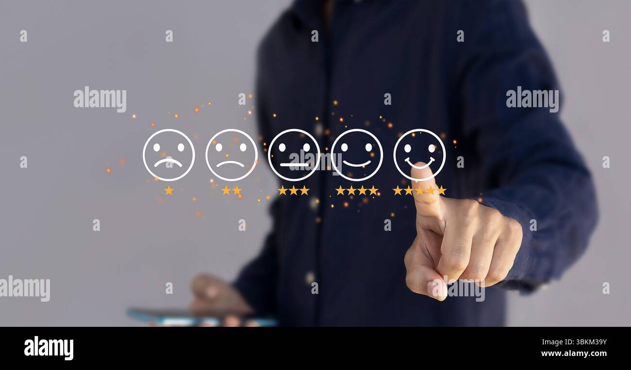 Valutazione del servizio clienti e concetto di feedback. Uomo d'affari che utilizza un computer portatile con l'icona della faccia sorridente. Foto Stock