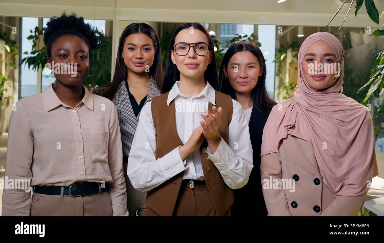 Felice soddisfatto multietnico donne gruppo eterogeneo cinque ragazze colleghi di lavoro team aziendale che annuisce testa applaudendo mani Foto Stock