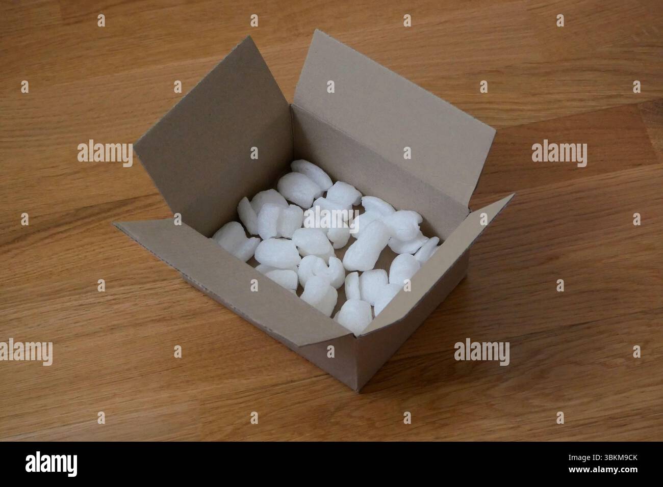 Imballaggio ecologico di una scatola per pacchi riempita con riempitivo biodegradabile. Il concetto di servizio di consegna e riciclaggio. Foto Stock