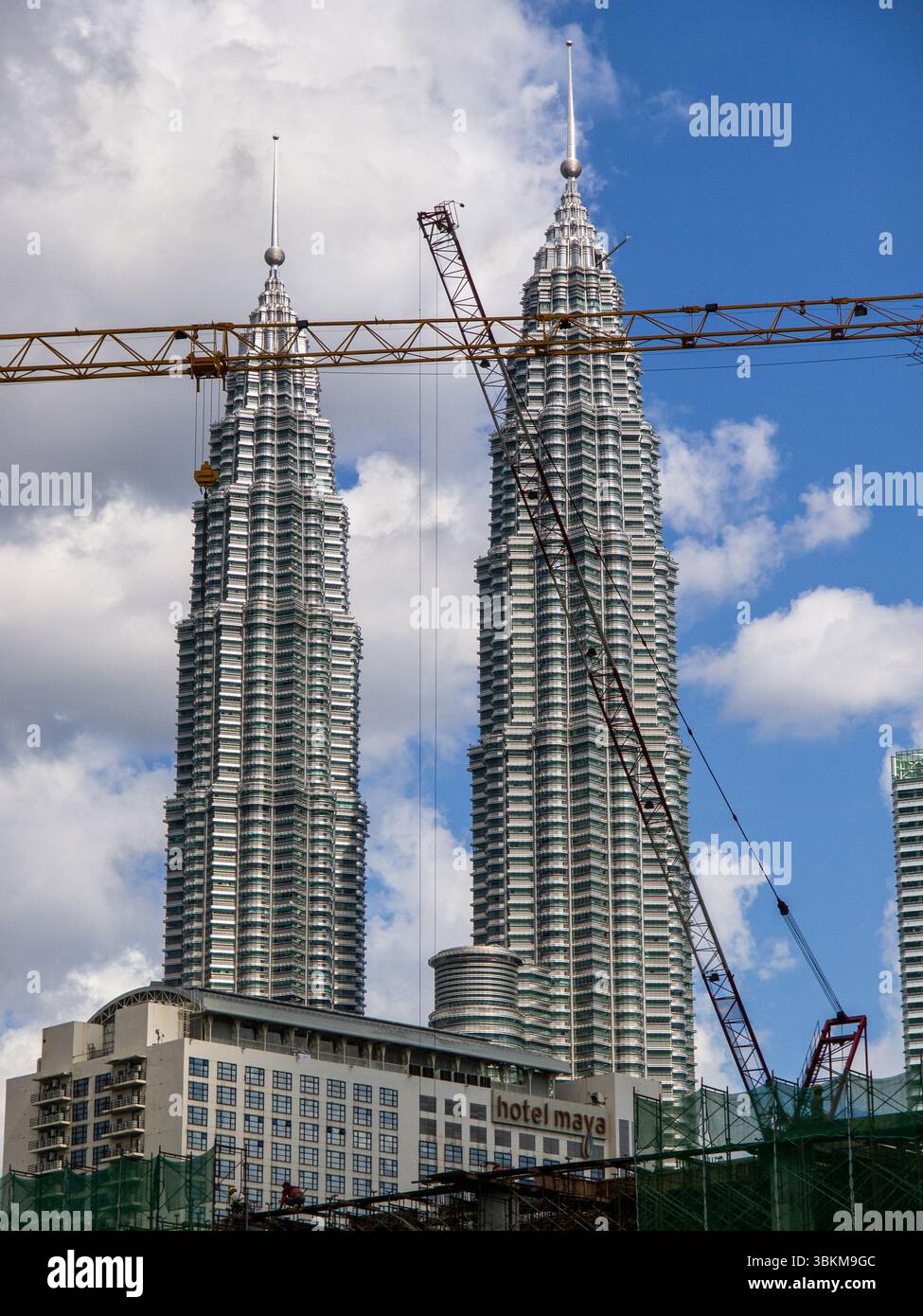 Kuala Lumpur, Malesia - 28 ottobre 2011 - cantiere e gru con le Torri Petronas sullo sfondo, cielo blu e nuvole. Foto Stock