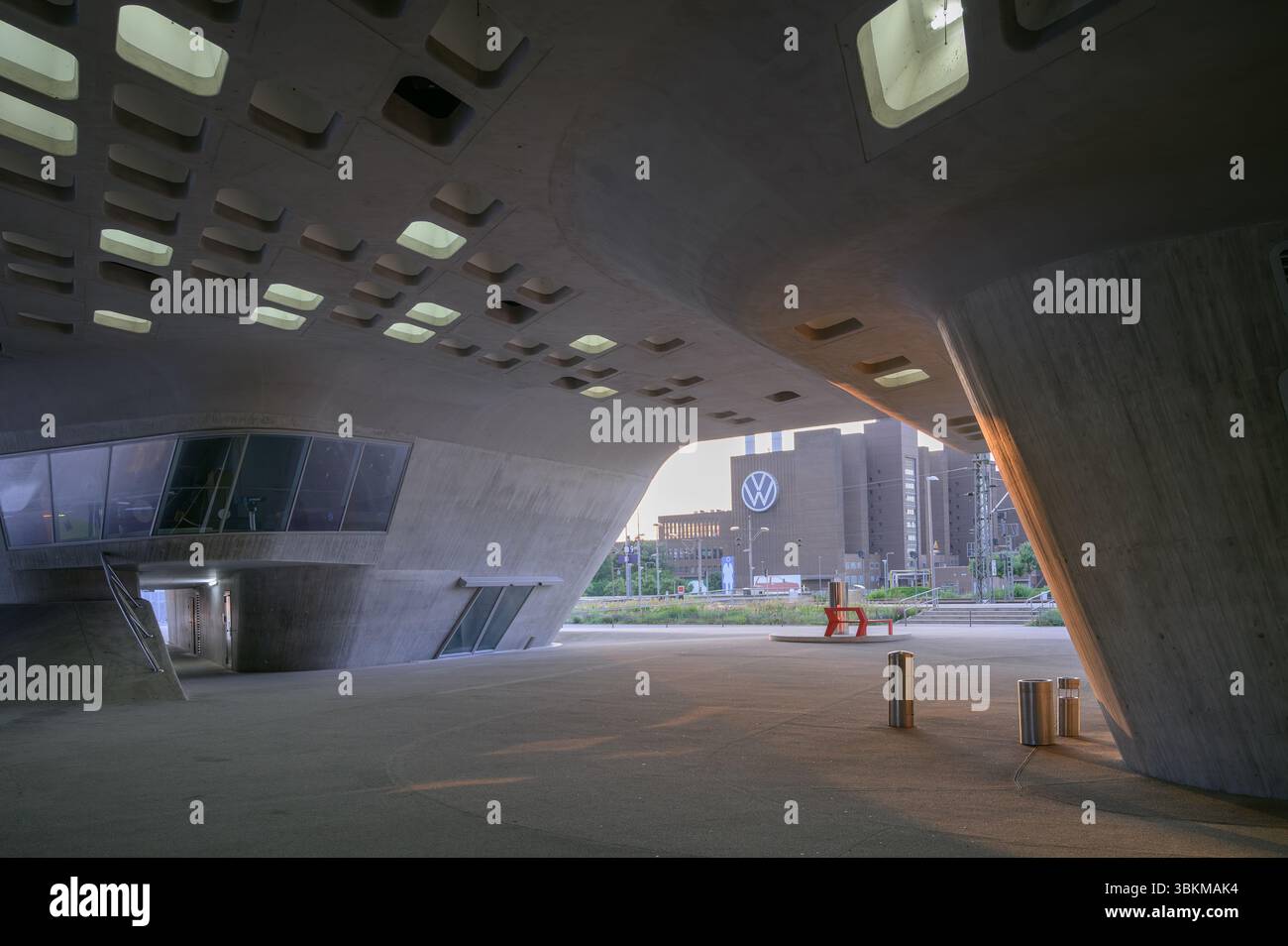 Wolfsburg, Germania - 17 giugno 2025: Il Phæno Science Center è un centro scientifico interattivo, lo sfondo mostra la centrale elettrica VW Foto Stock