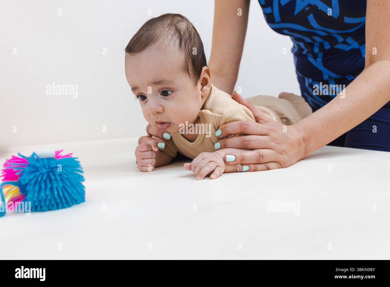 Attraverso la terapia fisica, il bambino costruisce la forza muscolare, la coordinazione e la stabilità per raggiungere le principali pietre miliari dello sviluppo Foto Stock