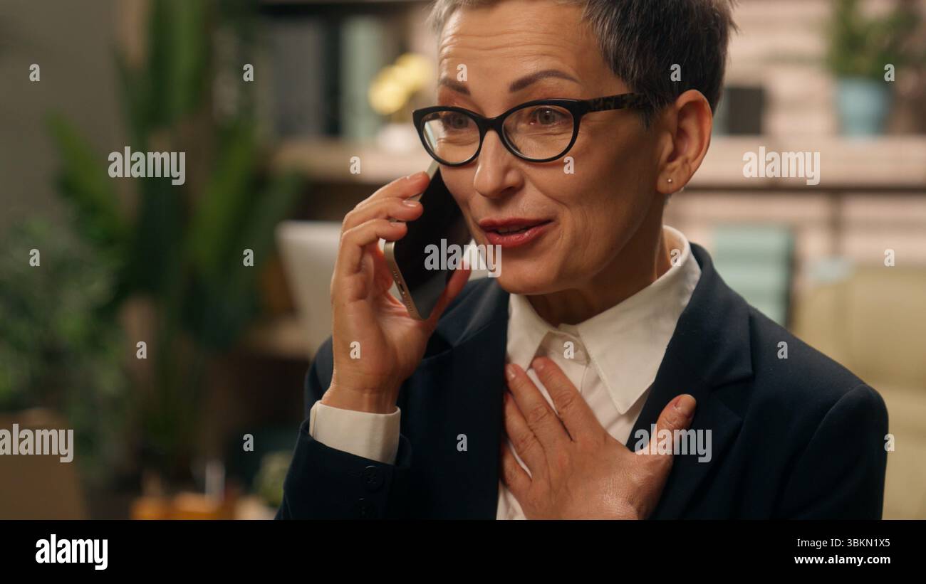 Ritratto in ufficio felice emotivo parlare stupito sorpreso grigio dai capelli anziani anziani anziani anziani anziani anziani anziani donna d'affari donna d'affari Foto Stock