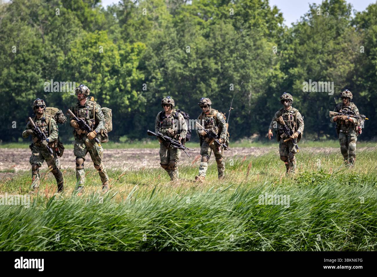 Le truppe della NATO camminano verso un punto di estrazione durante l'esercitazione militare Falcon Spring. Ossesluis, Paesi Bassi - 16 maggio 2025 Foto Stock