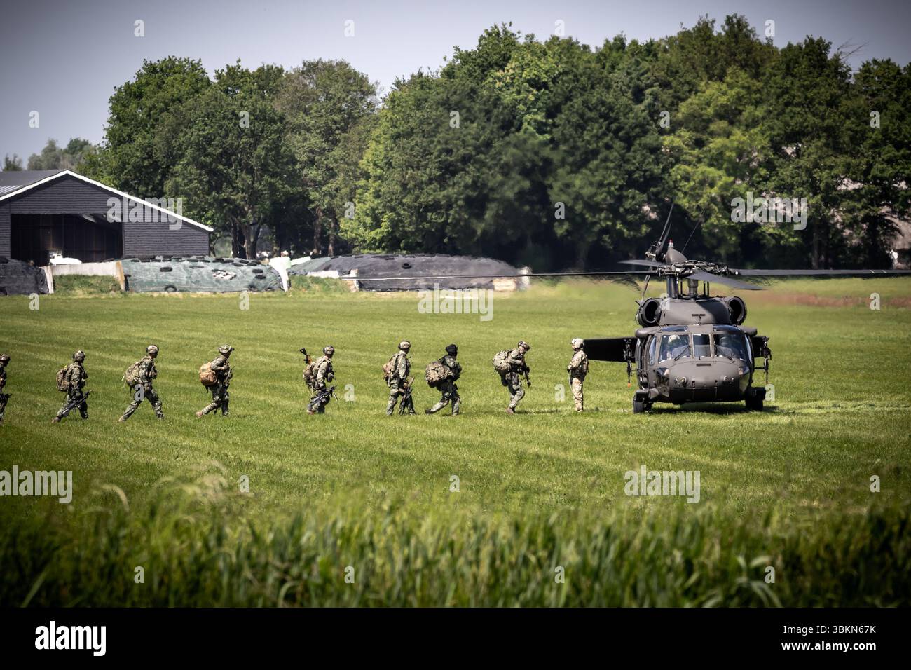 Le truppe della NATO camminano verso un elicottero UH-60 Blackhawk dell'esercito americano durante l'esercitazione militare Falcon Spring. Ossesluis, Paesi Bassi - 16 maggio 2025 Foto Stock