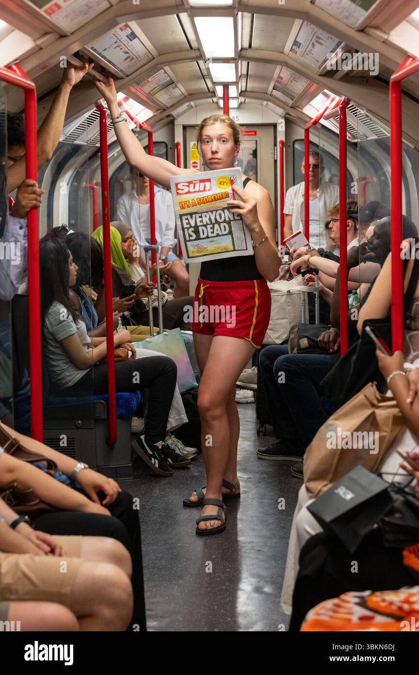 Londra, Regno Unito. 22 giugno 2025. Gli attivisti per il clima di Fossil Free London hanno messo in scena una divertente "sauna" sulla Central Line della metropolitana di Londra, chiedendo uno sciopero di calore mentre le temperature crescenti colpiscono le città di tutto il mondo. Crediti: Andrea Domeniconi/Alamy Live News Foto Stock
