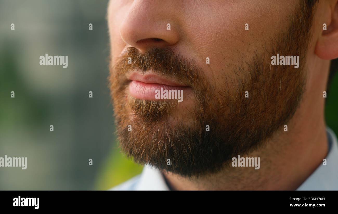 Primo piano vista ritagliata mezza bocca caucasica labbra calmo serio irriconoscibile setola europea barba setola uomo barbuto medicina per la pelle barbuta Foto Stock
