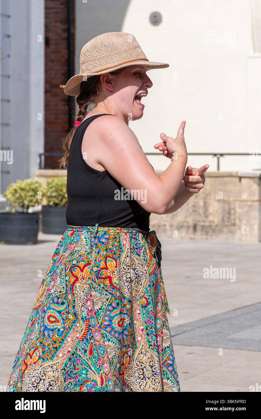 Un interprete della lingua dei segni che lavora in un evento, facilitando la comunicazione tra persone sorde e udenti. Inghilterra, Regno Unito Foto Stock