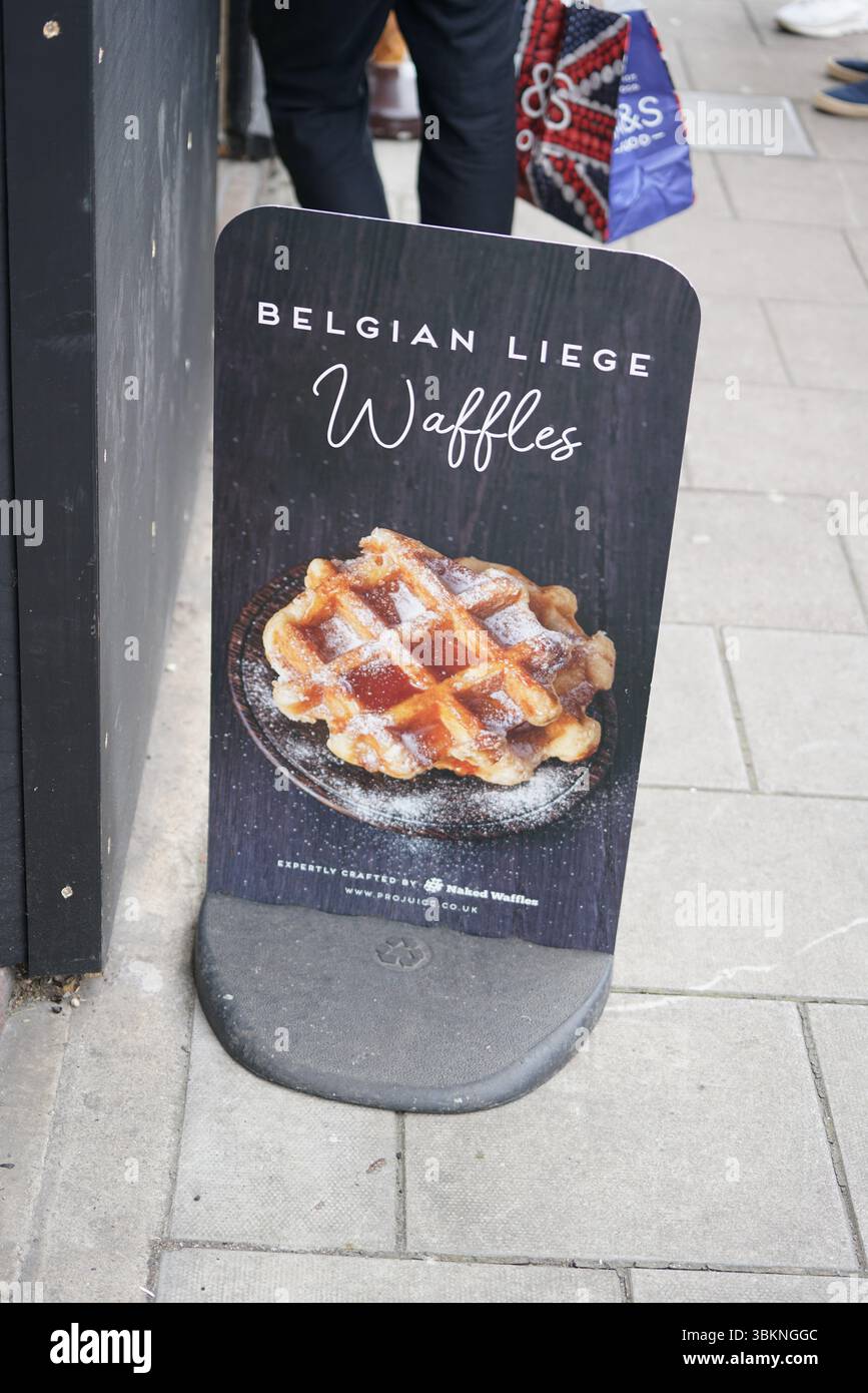 Insegna promozionale con deliziosi waffle belgi di Liegi su un marciapiede della città. Guildford, Inghilterra Foto Stock