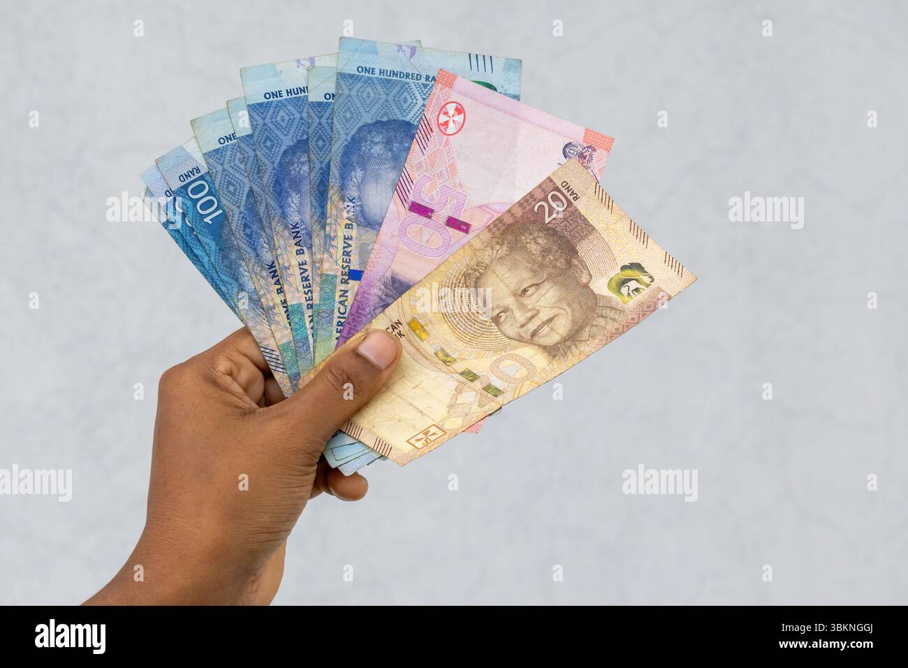 Valuta del Rand sudafricano in mano femminile, tra cui banconote da 20, 50 e 100 Rand. Concetto finanziario di ricchezza ed economia. Foto Stock