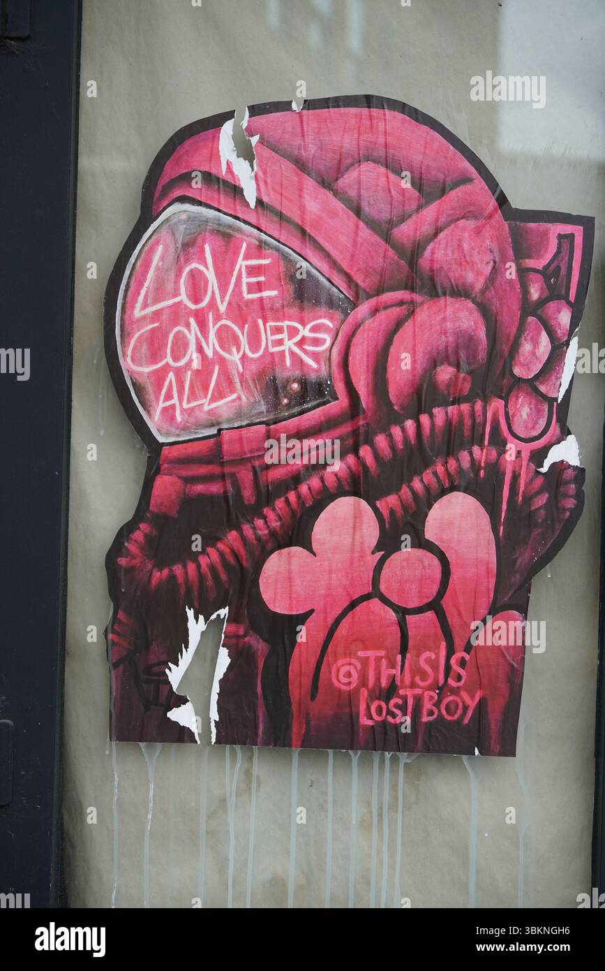 Colorata Street Art che raffigura un astronauta con un messaggio d'amore ispiratore. Arte di Thisis, ragazzo perduto. Guildford, Inghilterra Foto Stock