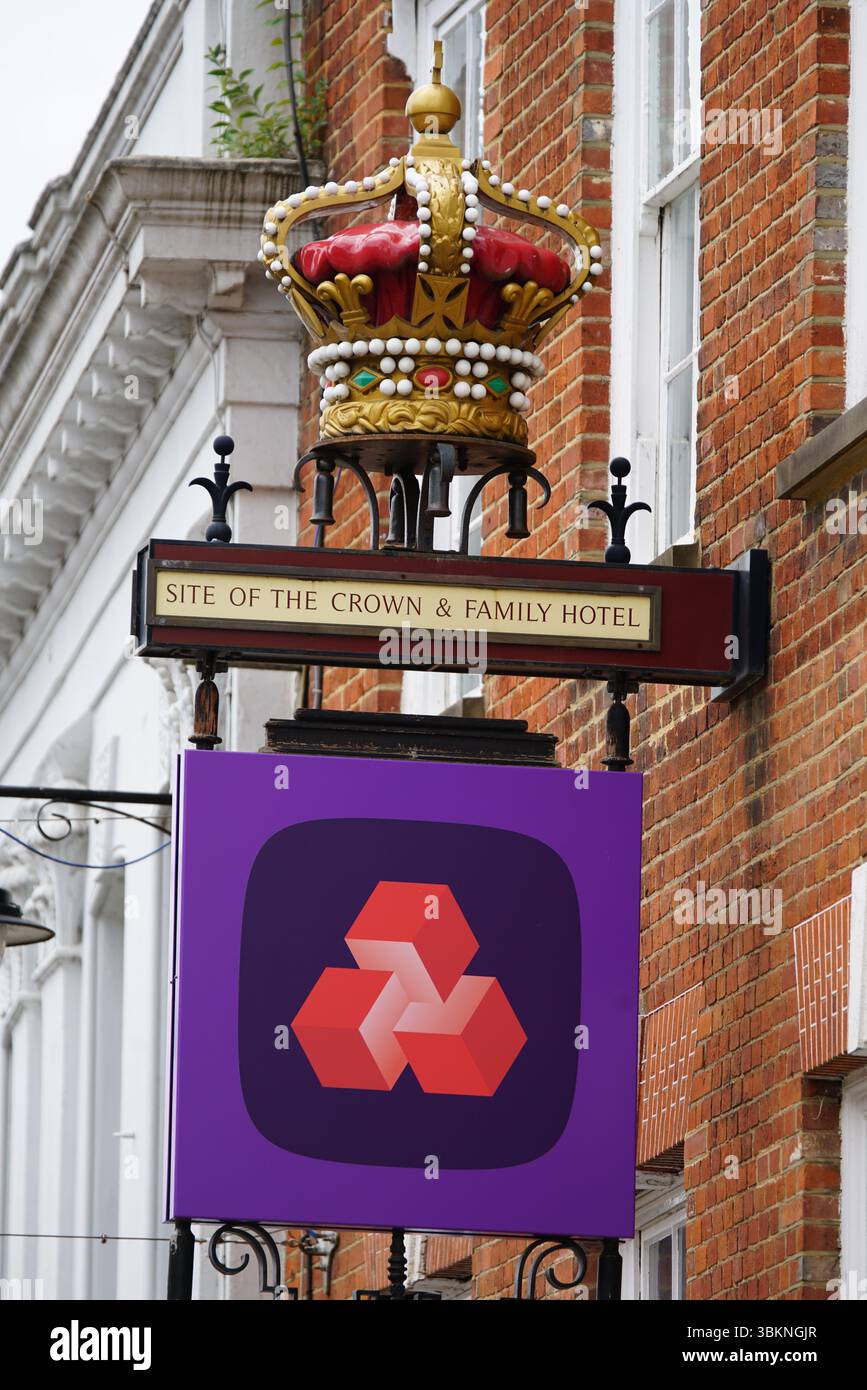 Insegna decorativa Crown e logo aziendale sull'esterno dell'edificio storico. Guildford, Inghilterra Foto Stock