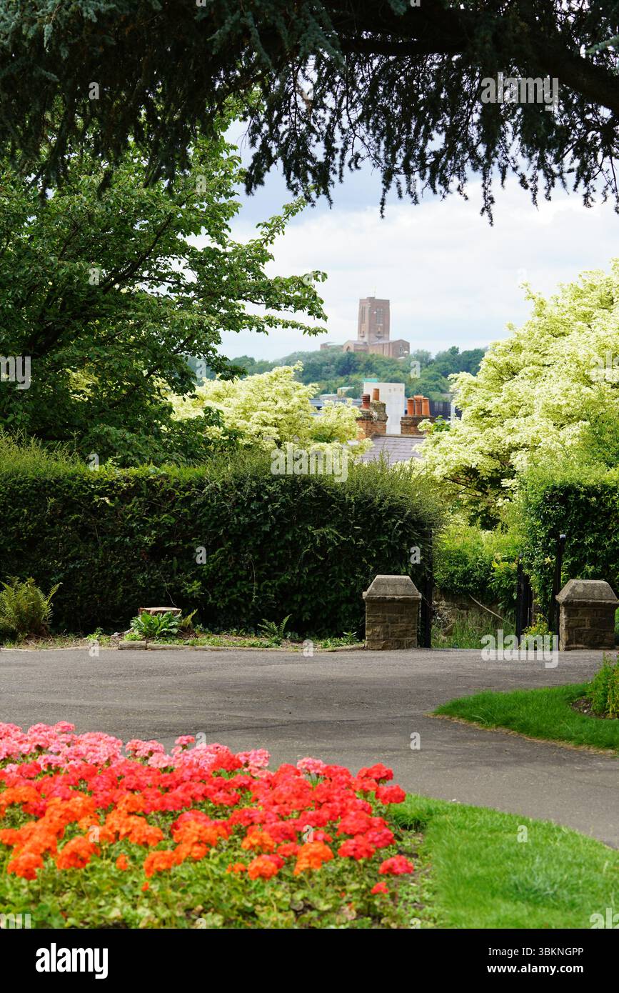 Vista panoramica del giardino con fiori colorati e architettura storica in lontananza. Guildford, Inghilterra Foto Stock