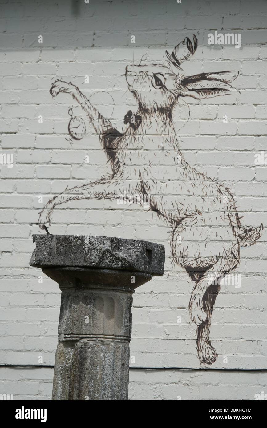 Stravagante murale di coniglio con antica colonna di pietra sul muro di mattoni. Guildford, Inghilterra Foto Stock
