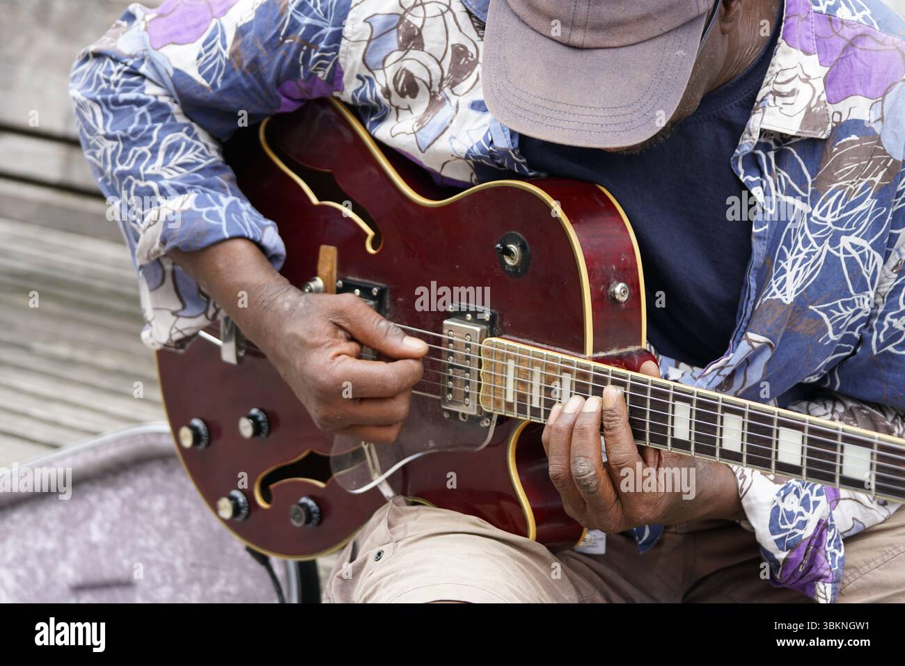 Primo piano di un musicista che suona una chitarra elettrica all'aperto con intensità. Guildford, Inghilterra Foto Stock