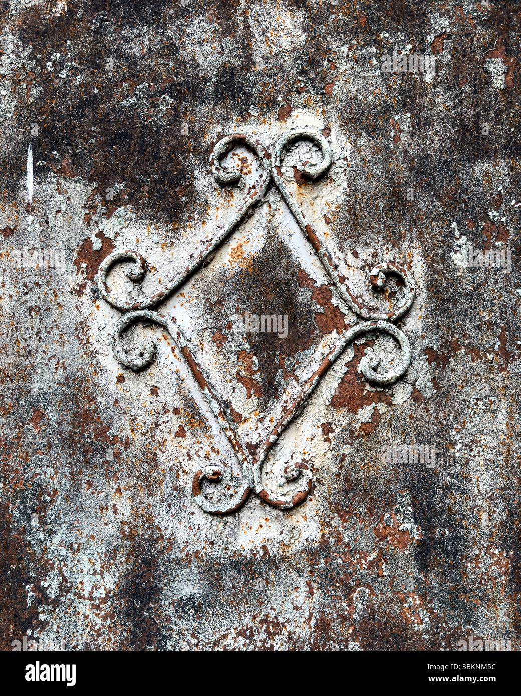 Primo piano di una superficie in ferro arrugginito con scrollwork decorativi, vernice invecchiata e patina. Ideale per sfondi, progetti e riferimenti 3D. Foto Stock