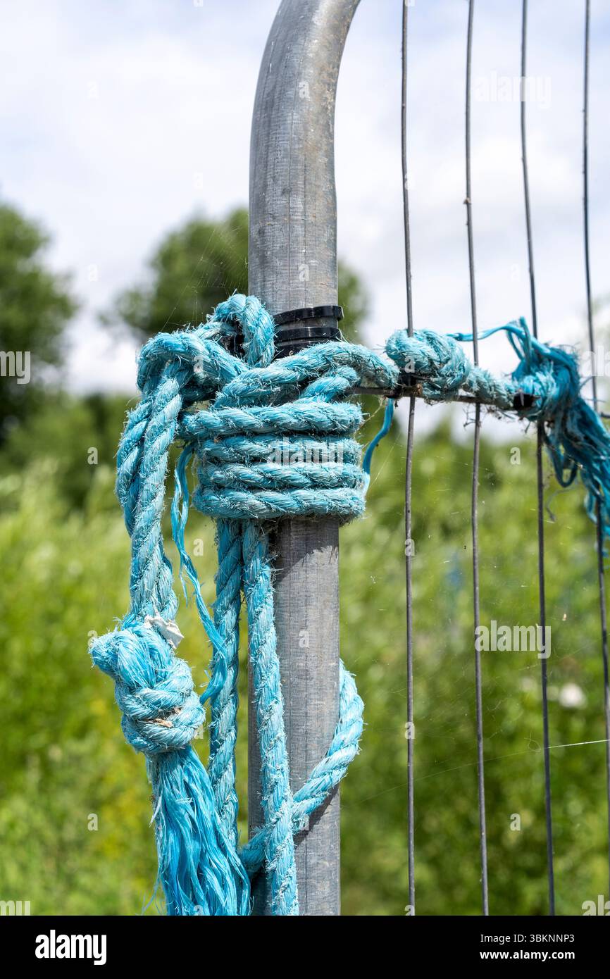 Corda blu annodata su asta metallica Foto Stock