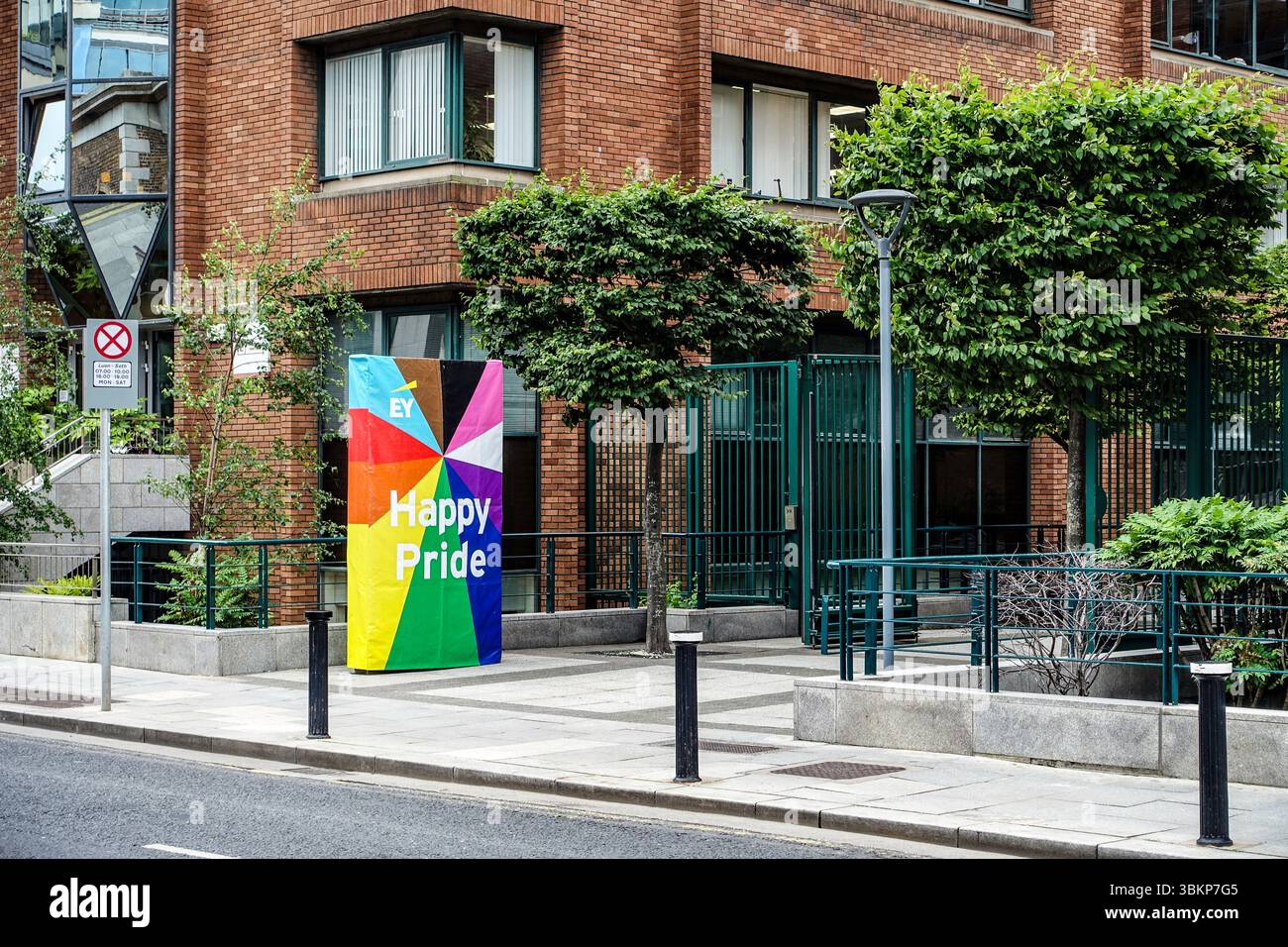 Un colorato striscione EY 'Happy Pride' fuori dall'Harcourt Centre in Harcourt Street, Dublino, che celebra il mese dell'orgoglio LGBTQ+ in un ambiente aziendale. Foto Stock