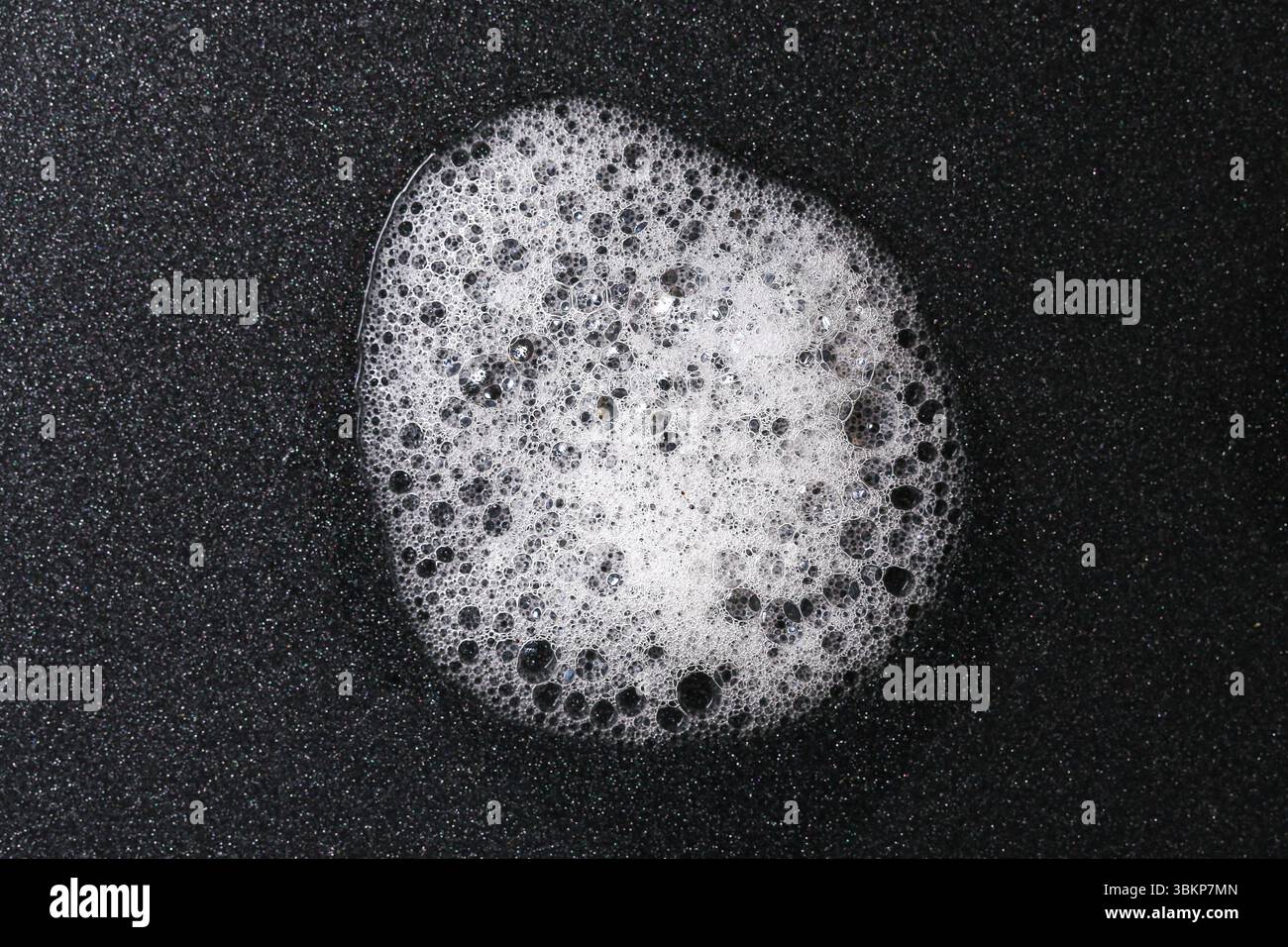 Bolla di schiuma di sapone bianca su sfondo nero. Concetto di pulizia astratta con consistenza detergente. Primo piano di suds con superficie lucida. Foto Stock