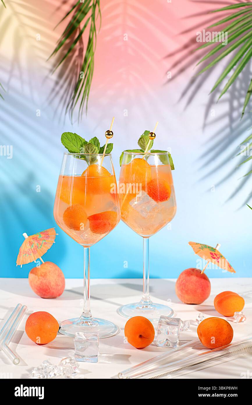 Natura morta moderna con frutta. Cocktail reale alla limonata con pesca, albicocca, mojito con tequila, gin, rum, ghiaccio e menta fresca, bar e party concept, Foto Stock