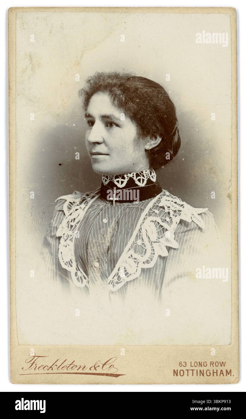 Originale carta de visite vittoriana (biglietto da visita o CDV) profilo di una donna vittoriana ventenne, con frange frizzy e panino chignon, collo alto in pizzo e choker. Fotografia dallo studio di Freckleton & Co, 63 Long Row West, Nottingham, Inghilterra, Regno Unito. circa 1898. Foto Stock
