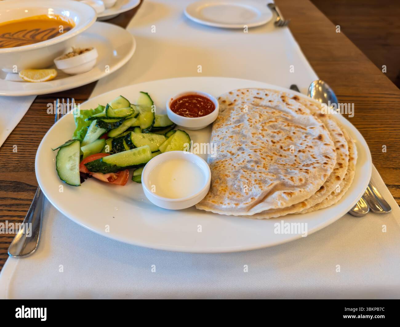 Tradizionale Yantyk tartaro di Crimea servito con insalata e salse fresche. Pranzo al ristorante con Yantyk e zuppa di lenticchie. Autentica cucina dell'Europa orientale Foto Stock