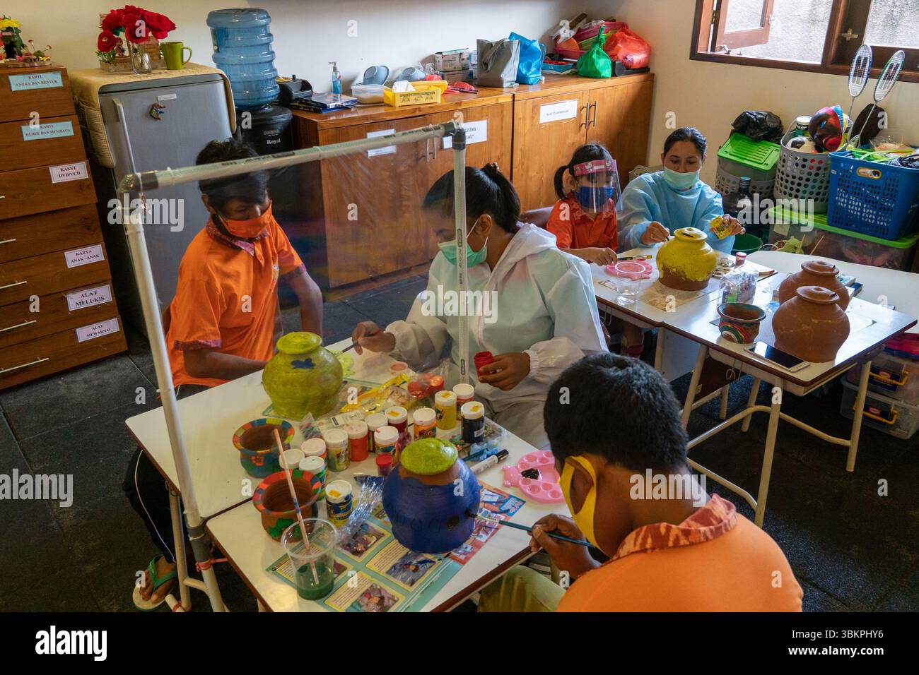 Bali, 23 ottobre 2020: I bambini con disabilità dipingono ceramiche allo YPK Bali, esplorando la creatività in un ambiente educativo inclusivo e di supporto Foto Stock