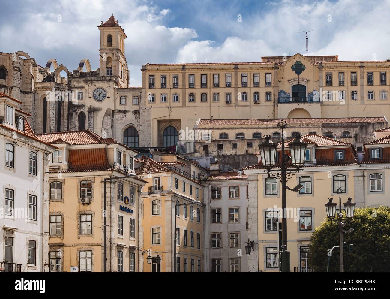 Vista panoramica del centro storico di Lisbona con le rovine del convento del Carmo, i classici edifici portoghesi e i decorati lampioni stradali, perfetti per viaggi, storia e temi architettonici. Foto Stock