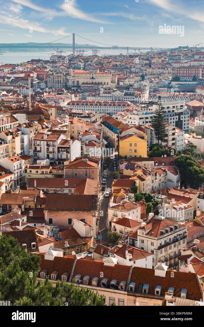 Vibrante vista aerea di Lisbona, Portogallo, con i tradizionali tetti rossi, le strade tortuose e il famoso Ponte 25 de Abril sotto un cielo blu brillante, perfetto per i blog di viaggio. Foto Stock