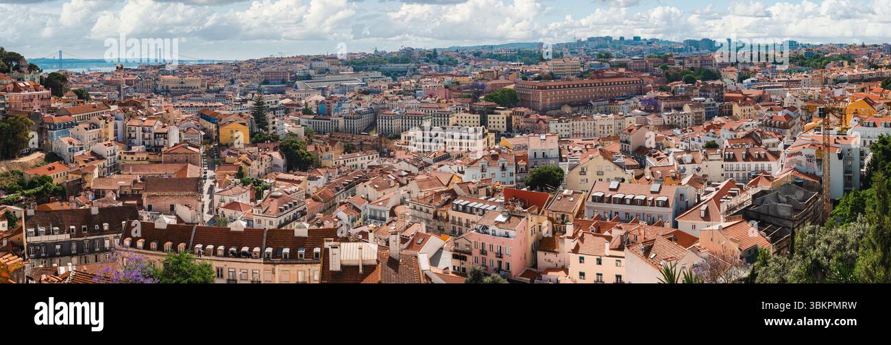 Splendida foto panoramica di Lisbona, Portogallo, che mostra i tetti storici della città, l'architettura vivace e il famoso Ponte 25 de Abril sotto a. Foto Stock