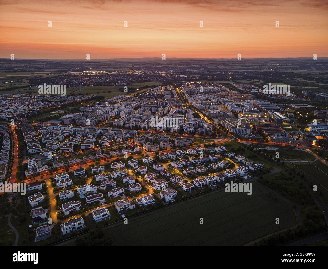L'alba dietro il quartiere Riedberg di Francoforte annuncia l'imminente alba. (Vista aerea con drone), Germania, Europa Foto Stock