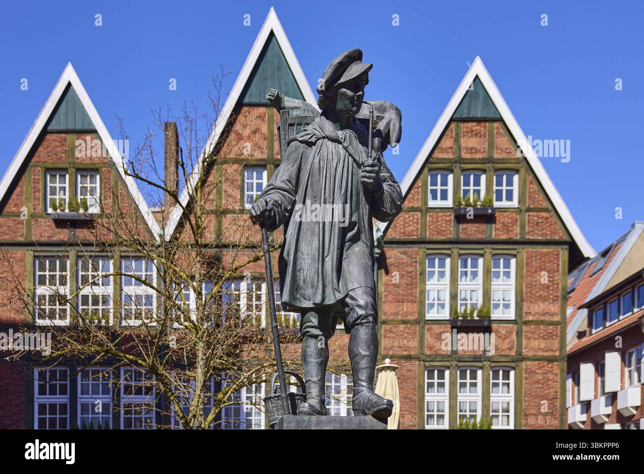 Monumento di Kiepenkerl, scultura in bronzo, architettura in mattoni, facciata, finestra, profondità di campo, cielo azzurro senza nuvole, Spiekerhof, Muenster, Muensterland, ind Foto Stock
