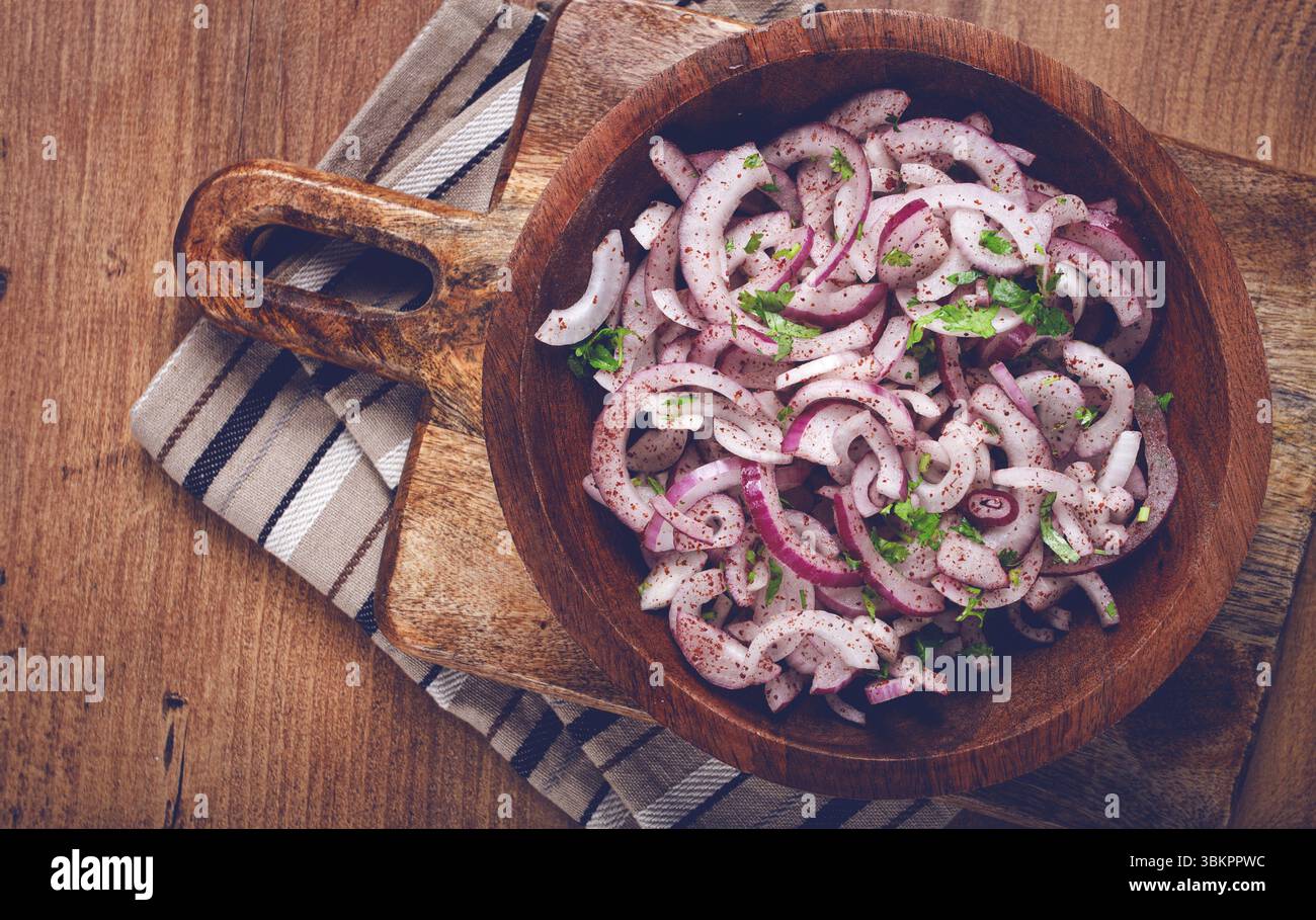 Cipolla rossa tritata, con sumac ed erbe aromatiche, in un recipiente, cipolla spagnola sottaceto, vista dall'alto Foto Stock