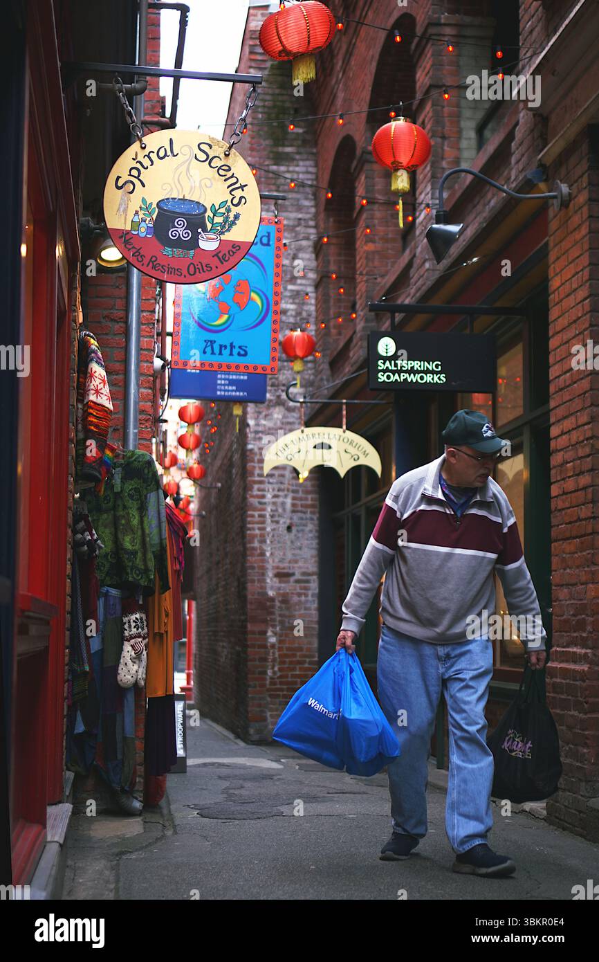 Fan Tan Alley (la strada più stretta del Canada) Shopper nella Chinatown più antica e storica del Canada a Victoria, Isola di Vancouver, Columbia Britannica, Canada Foto Stock