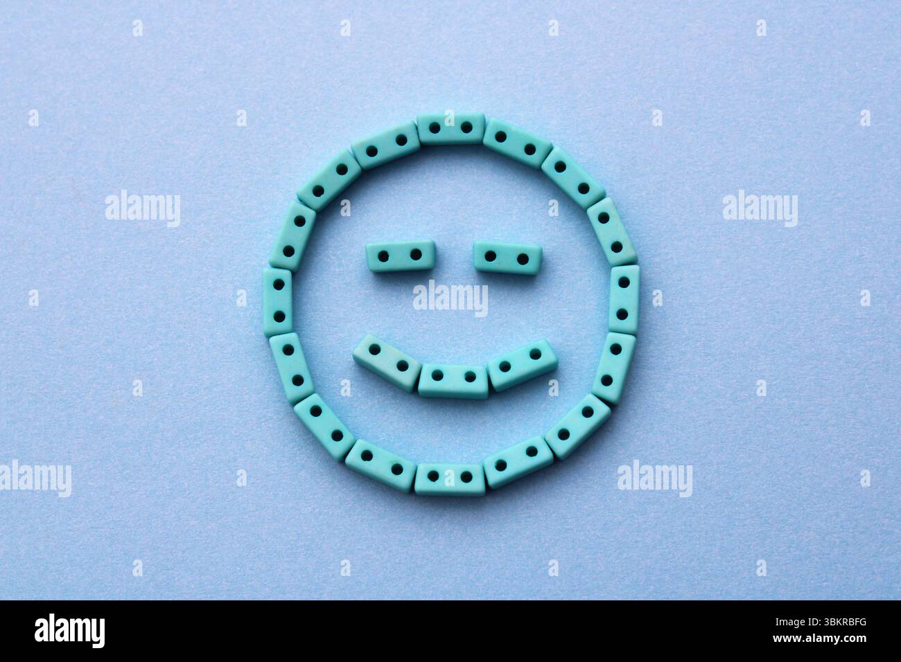 Perline a forma di blocco che formano un volto felice Foto Stock