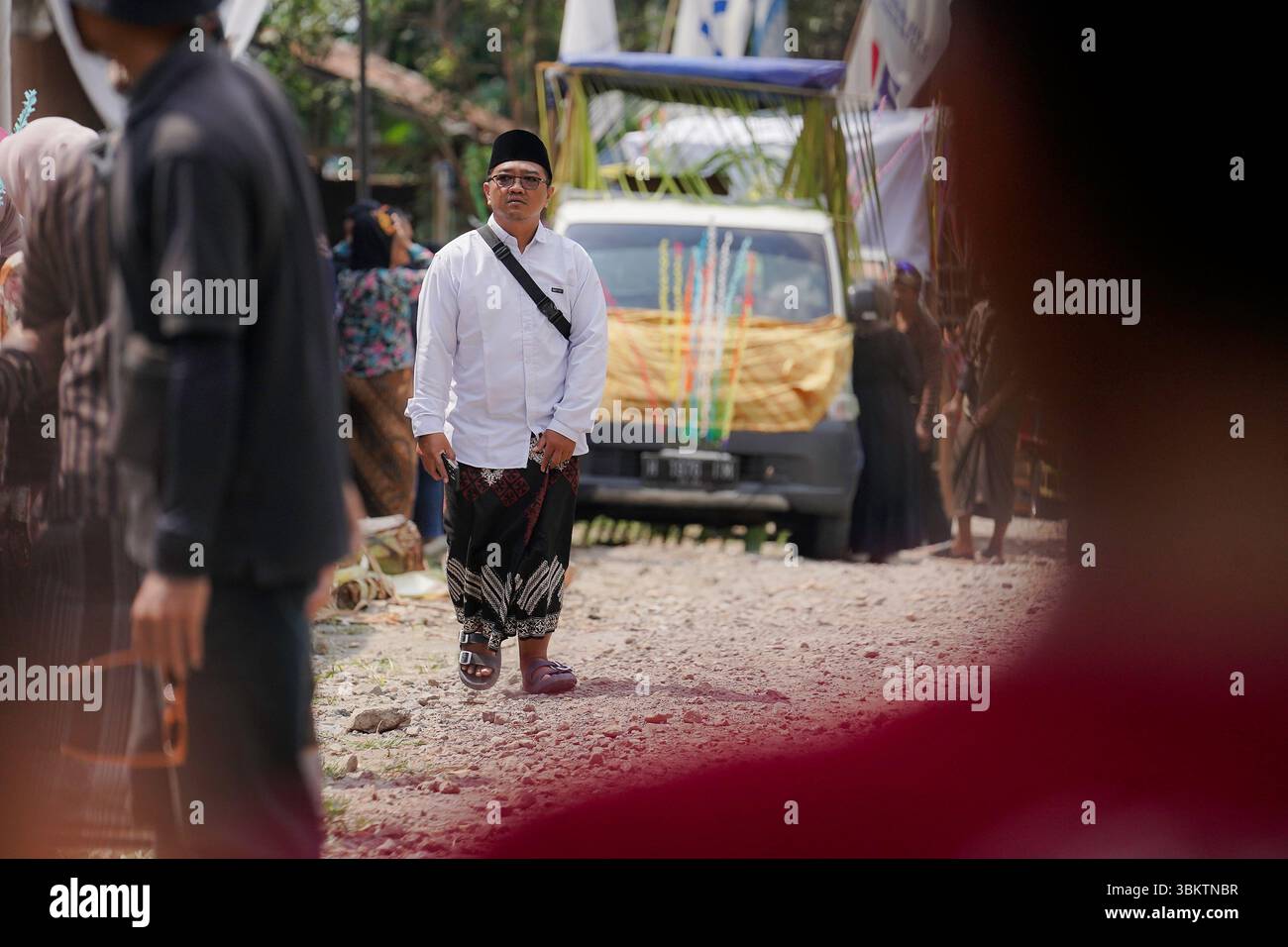 Un uomo in abito tradizionale bianco si erge durante il Kirab Budaya Ngabean 2024 a Giava centrale, Indonesia. Foto Stock