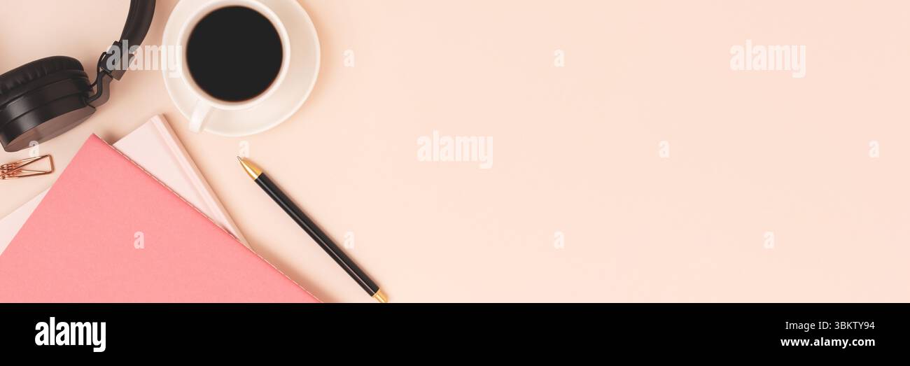 Banner con copybook, tazza di caffè e cuffie su sfondo beige. Foto Stock
