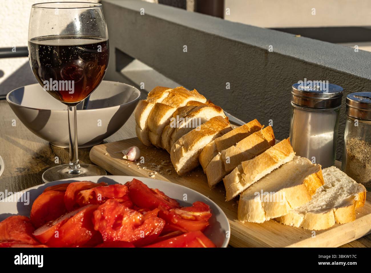 Bicchiere di vino, antipasto, vino rosso, cena, vino della Croazia, pomodori rossi, olio d'oliva, pane fresco, disposti su piatti su un tavolo in terrazza, Foto Stock