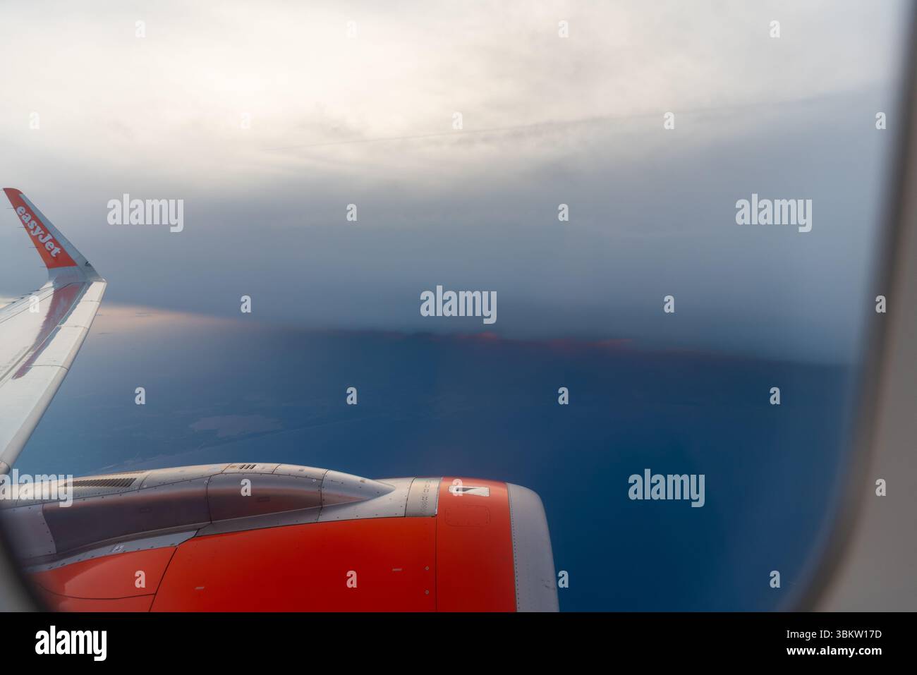 Vista di un tramonto sotto un forte banco nuvoloso dalla finestra di un aereo Airbus A320 easyJet sopra l'Europa. Andare in giro con il maltempo Foto Stock Vista di un tramonto sotto un forte banco nuvoloso dalla finestra di un aereo Airbus A320 easyJet sopra l'Europa. Andare in giro con il maltempo Foto Stock