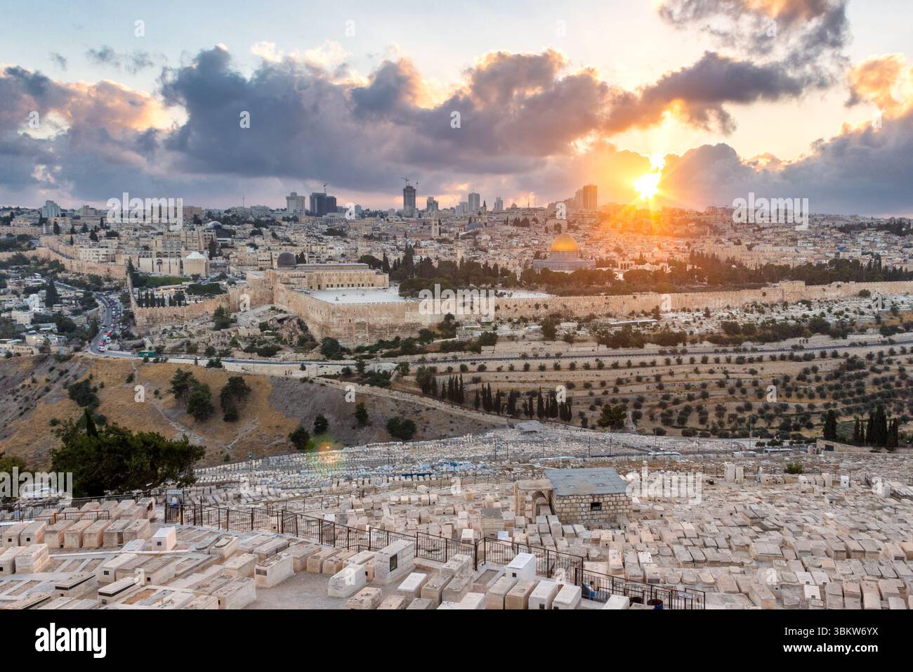 Il sole tramonta dietro la città vecchia di Gerusalemme, come si vede dalle pendici del Monte degli Ulivi e dal suo antico cimitero Foto Stock