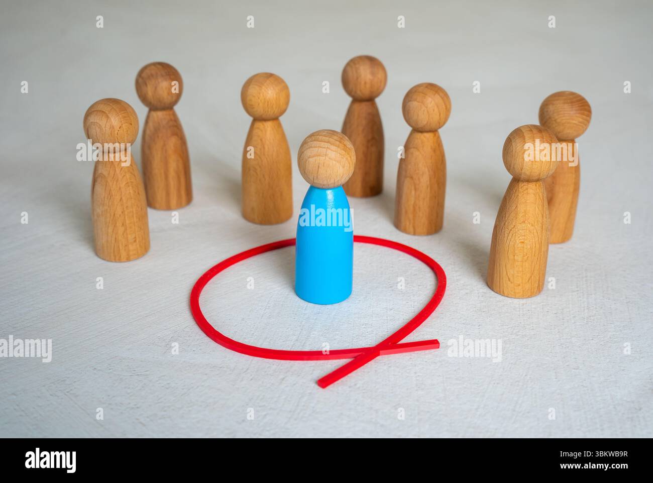 La figura umana blu è separata dal resto della gente da un cerchio rosso. Spazio personale. Impostazione dei limiti. Isolamento dalla società. Individuale Foto Stock