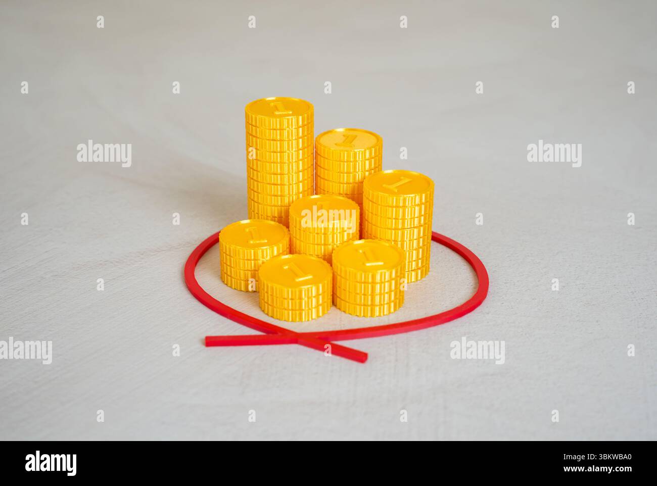 Pile di monete sono cerchiate in rosso. Assegnare fondi. Trova le finanze. Spesa pubblica, finanziamento di progetti o distribuzione della ricchezza. Foto Stock