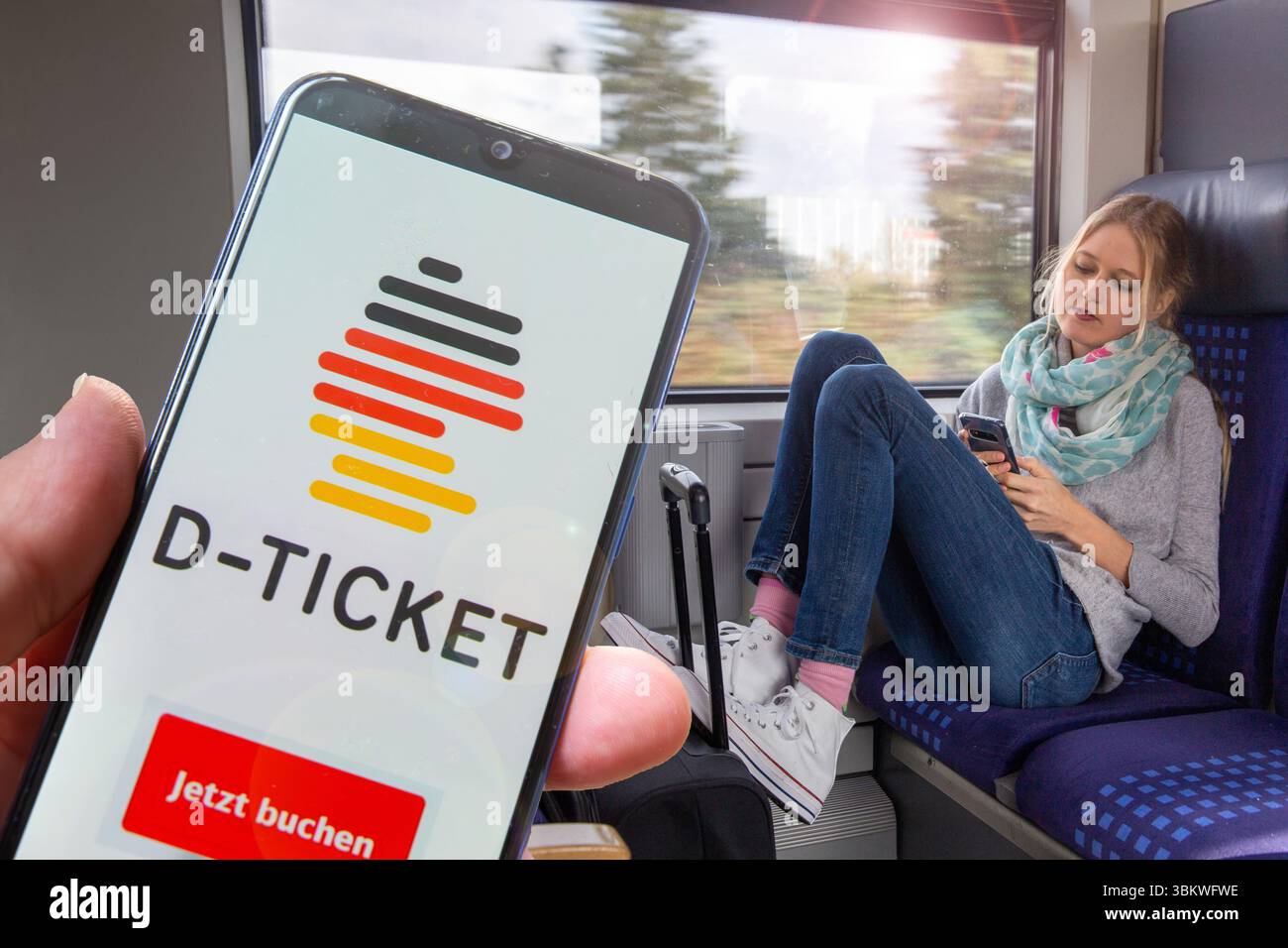 (Fotomontaggio) Logo del Deutschlandticket sullo smartphone, sullo sfondo una giovane donna sul treno Foto Stock