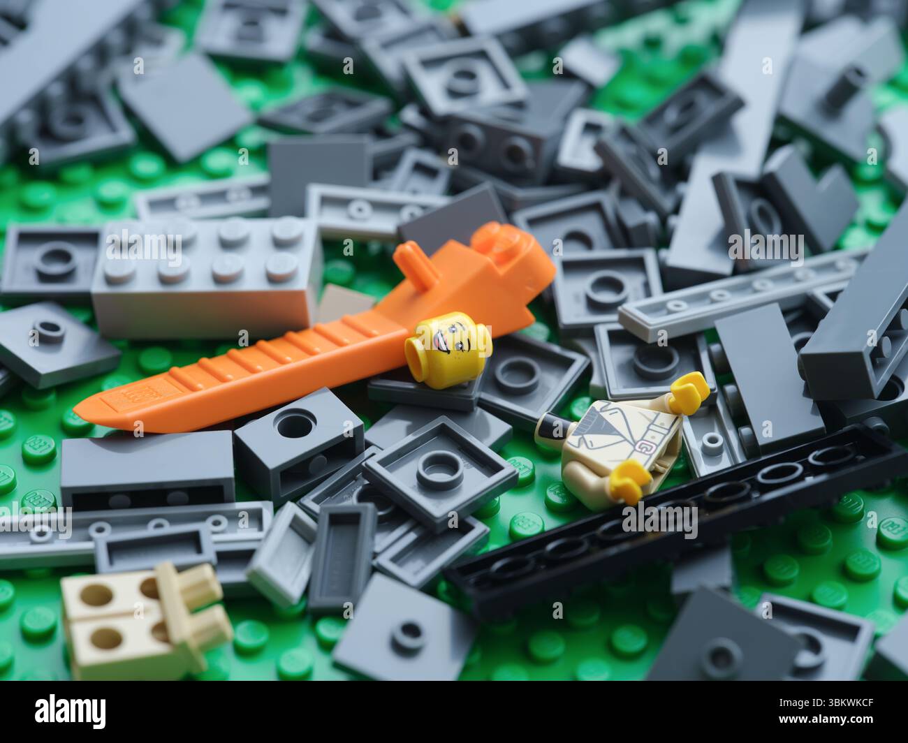 Tambov, Federazione Russa - 21 giugno 2025 Una pila di pezzi Lego con un separatore di mattoni su una piastra base Lego verde. Primo piano. Foto Stock