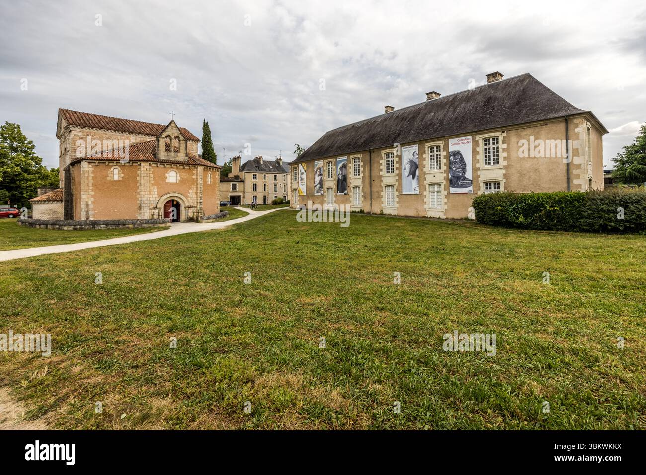 Proprio accanto al Battistero di San Giovanni (Baptistère Saint-Jean, Battistero di San Giovanni) in Rue Jean-Jaurès a Poitiers, Nouvelle-Aquitaine, Francia, si trova il Musée Sainte-Croix (Museo della Santa Croce), il più grande museo della città. A destra si erge un lungo edificio con un tetto a padiglione, la sua facciata adornata da grandi striscioni che mostrano immagini monocromatiche. A sinistra si trova il battistero con i suoi tetti di tegole rosse, e un sentiero attraversa il prato. Il museo è stato inaugurato nel 1974 sul sito dell'ex Abbazia di Sainte-Croix. Ospita ampie mostre permanenti di archeologia, arte e storia. La Sainte- Foto Stock