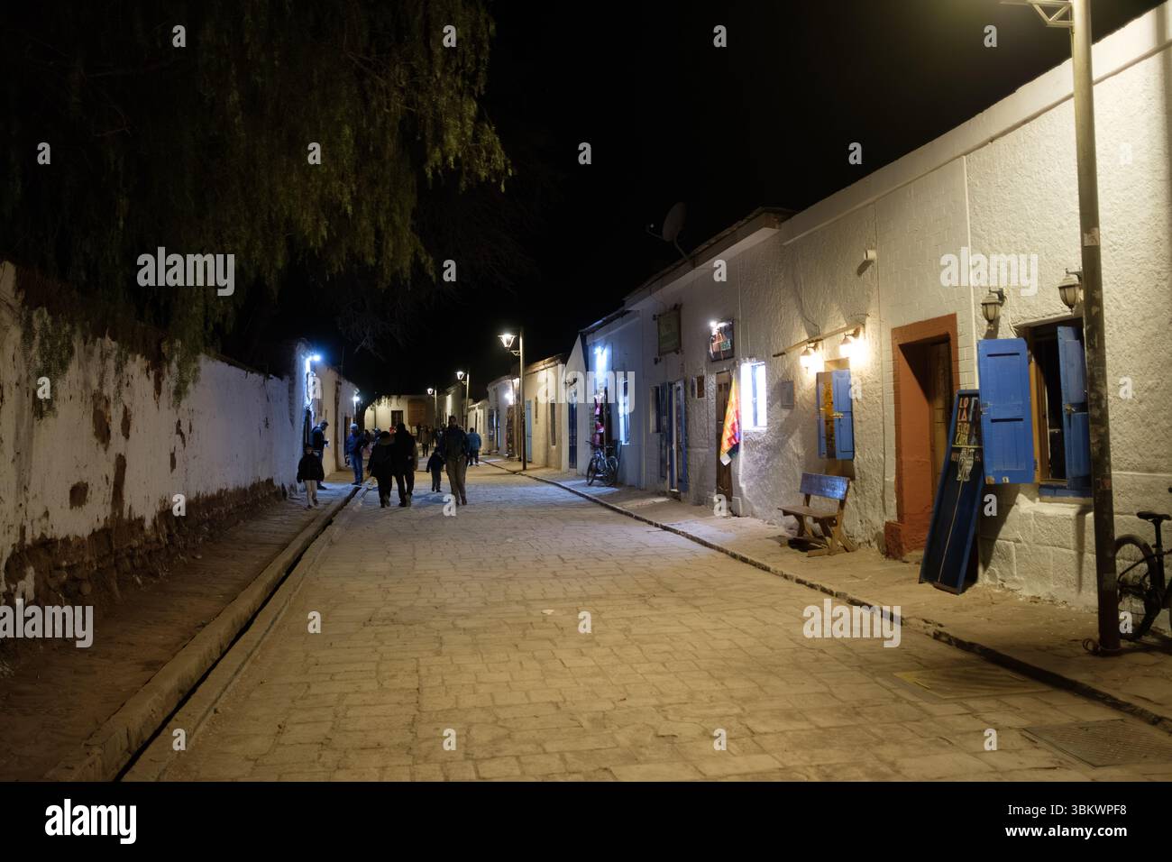 I turisti esplorano una strada affascinante a San Pedro de Atacama di notte. Foto Stock