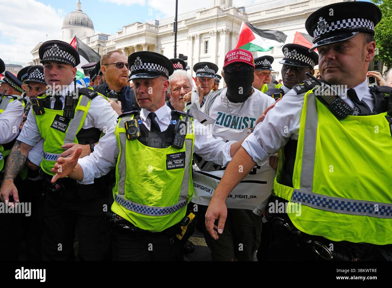 La polizia rimuove un piccolo contingente di sostenitori filo-israeliani da una manifestazione a Trafalgar Square a Londra, dove le persone si sono riunite a sostegno dell’azione palestinese. Il Ministro degli interni si sta preparando a vietare l'azione palestinese a seguito del vandalismo del gruppo di due aerei in una base della RAF, rendendolo un reato appartenere o sostenere l'azione palestinese. Data foto: Lunedì 23 giugno 2025. Foto Stock