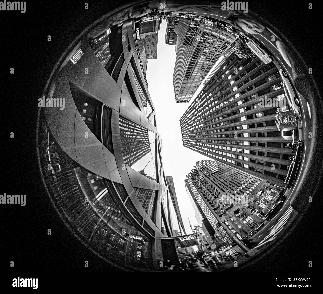 Obiettivo fisheye rivolto verso il cielo verso i grattacieli torreggianti di Manhattan, New York City, catturando la spettacolare architettura urbana e il cielo blu. Foto Stock