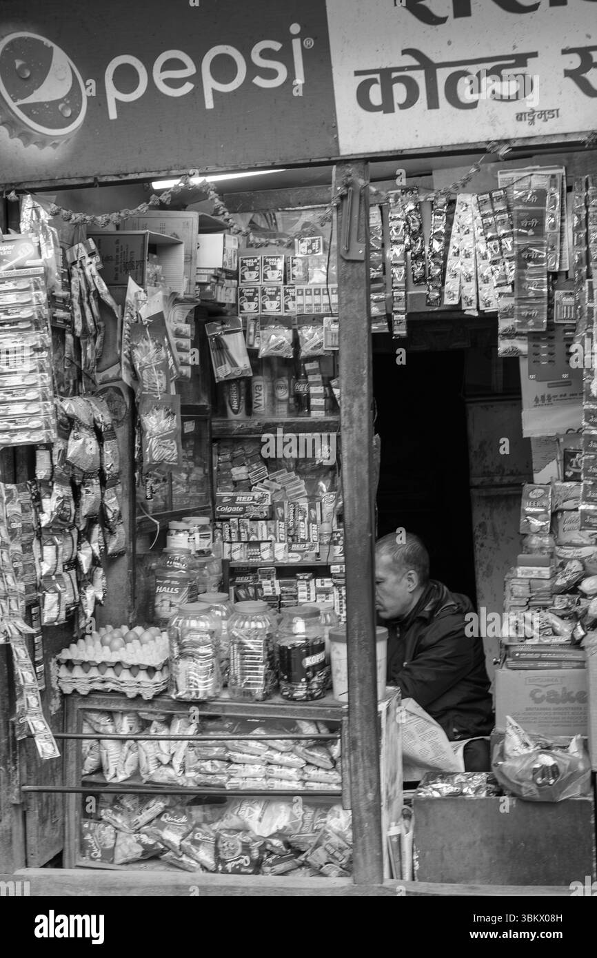 Il negoziante fa una pausa all'interno del suo negozio. Foto Stock