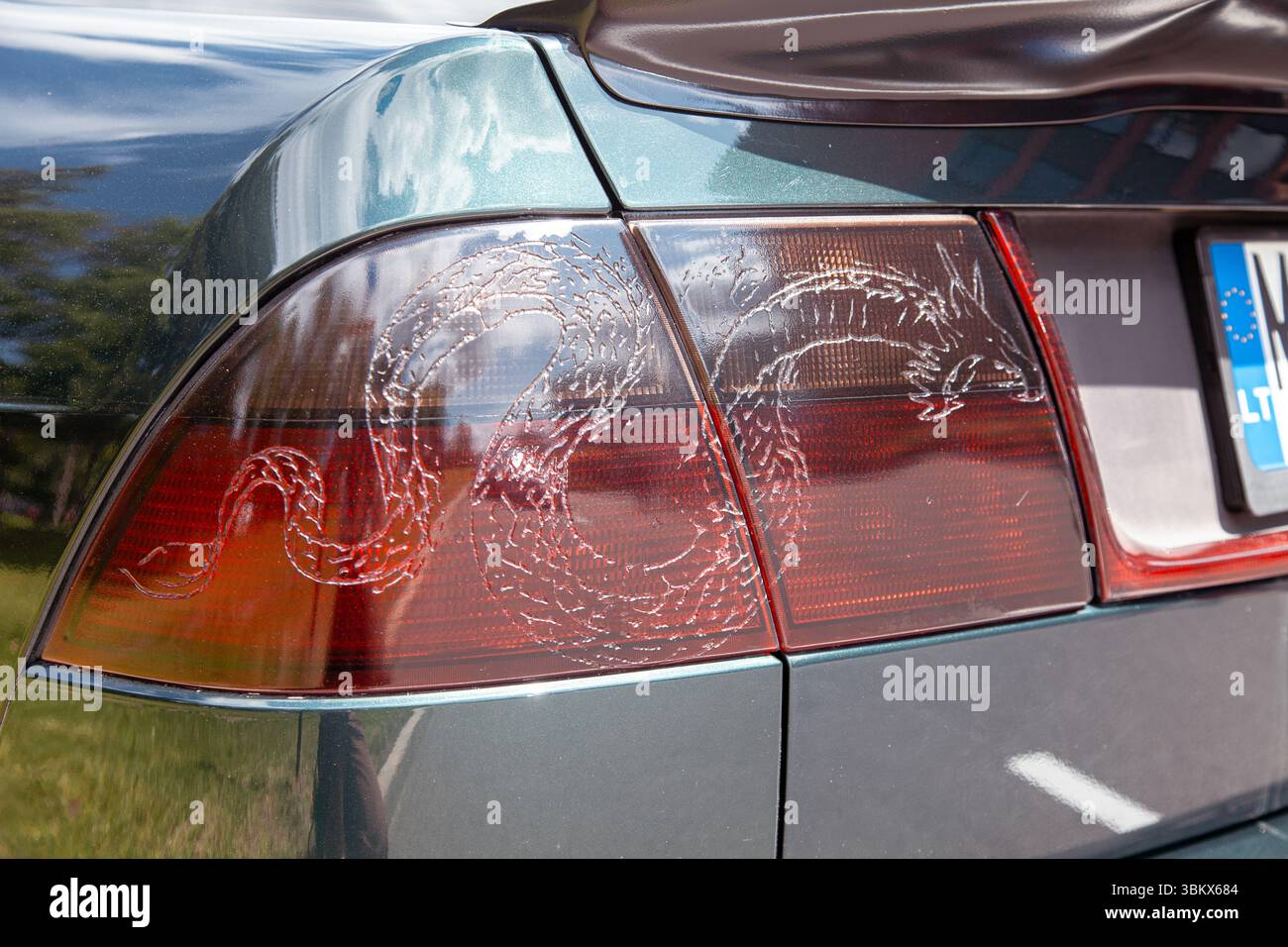 Primo piano di una luce di posizione posteriore personalizzata per auto con motivo a drago inciso, che mette in risalto l'esclusivo design post-vendita e gli artistici dettagli automobilistici Foto Stock